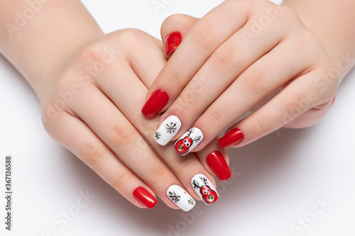 New Year's red and white manicure with snowflakes and painted deer on long square nails close-up on a white background