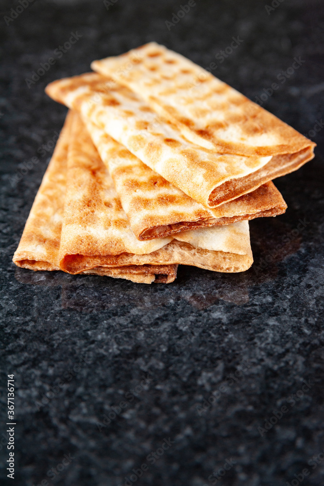 Fototapeta premium Three fried crispy cookies piled on black marble. Freshly baked cookies. Selective soft focus.