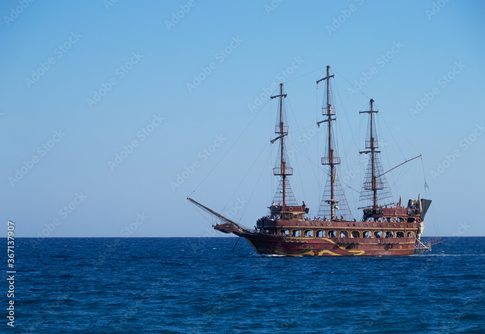 The painted brown ship made like an ancient sailing ship swimming in the sea. Copy space. Horizontal orientation. The painted brown ship made like an ancient sailing ship swimming in the sea. Copy space. Horizontal orientation.