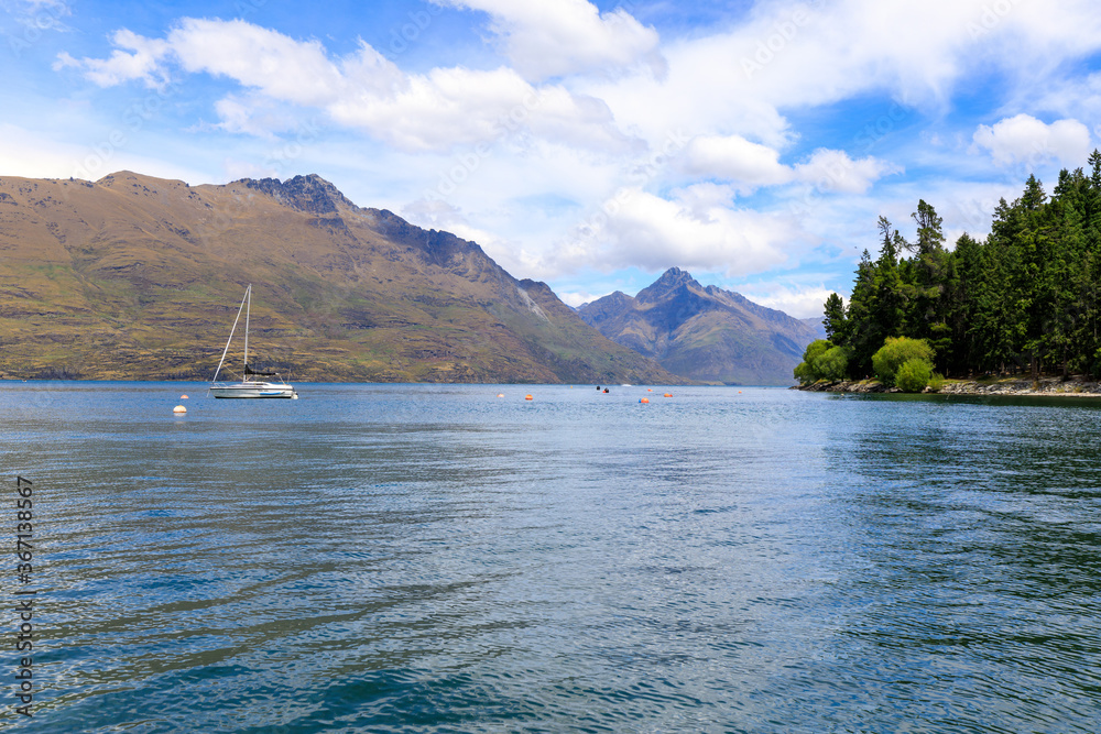 A sailing boat on Lake Wakatipu with mountains in the background. Queenstown, New Zealand. A sailing boat on Lake Wakatipu with mountains in the background. Queenstown, New Zealand.