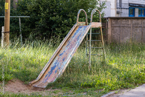 An old metal slide for children. An old playground.