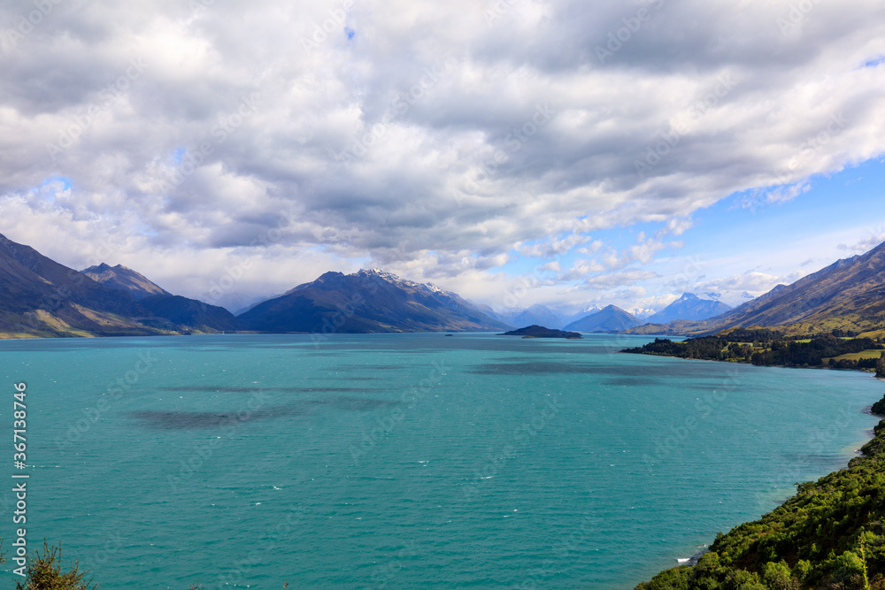 The view of Lake Wakatipu with clouds covering the snow-capped mountains in the distance. From the view of Bennetts Bluff Lookout. The view of Lake Wakatipu with clouds covering the snow-capped mountains in the distance. From the view of Bennetts Bluff Lookout.