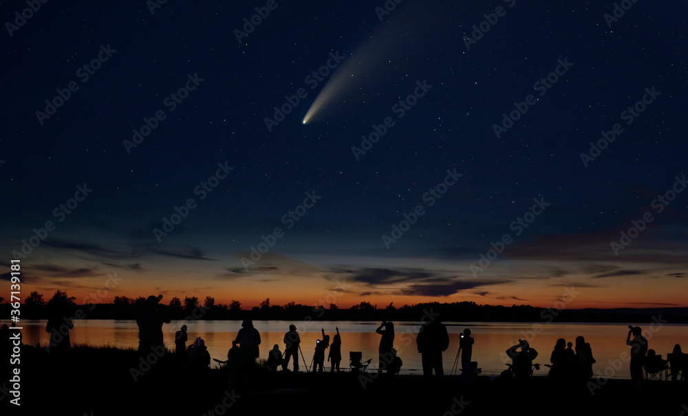 Comet Neowise comet C/2020 F3 (NEOWISE) and crowd of people silhouetted by the Ottawa river watching and photographing the comet
