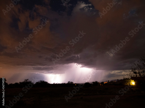A dramatic desert monsoon storm at night with lightning