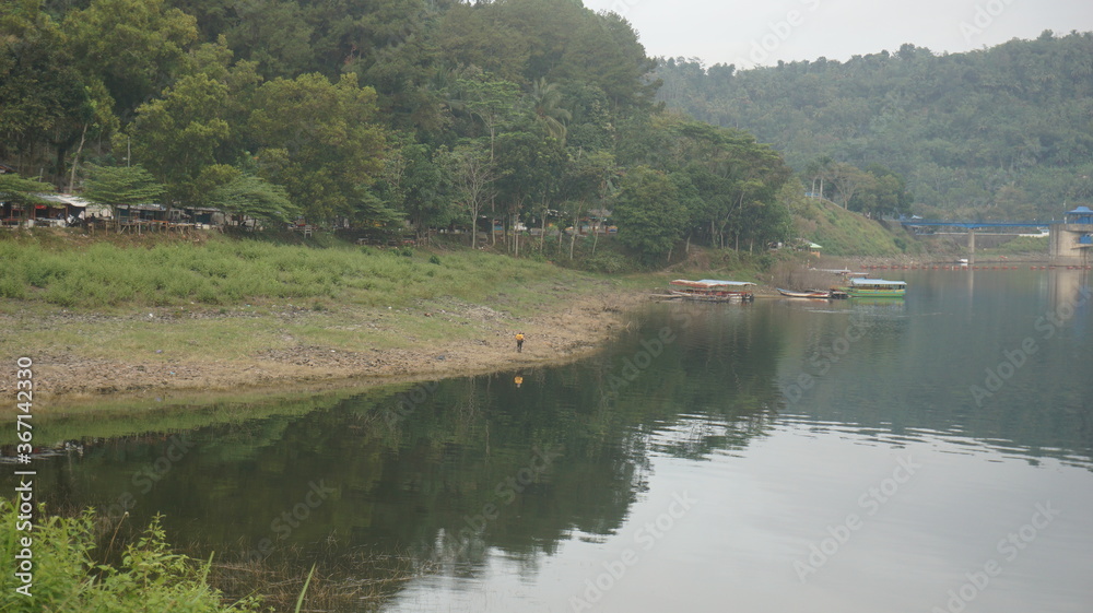 The view of the Lake is very clear which is flanked by hills and there are fishing boats. Landscape photos. Suitable for wallpaper or print