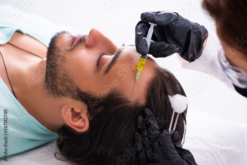 Young man visiting female beautician in hair transplantation con
