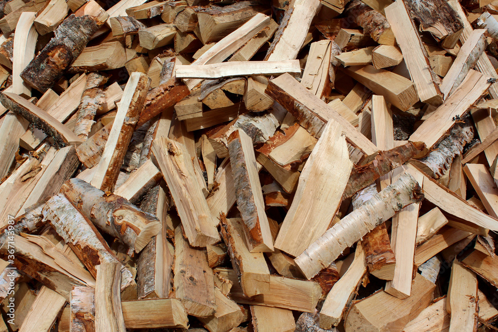 Dry chopped pile of firewood from logs. Preparation of firewood for the winter. Stacks of firewood. Wooden background. Dry chopped pile of firewood from logs. Preparation of firewood for the winter. Stacks of firewood. Wooden background.