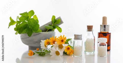 Wild flowers and herbs, mortar and pestle isolated on white background