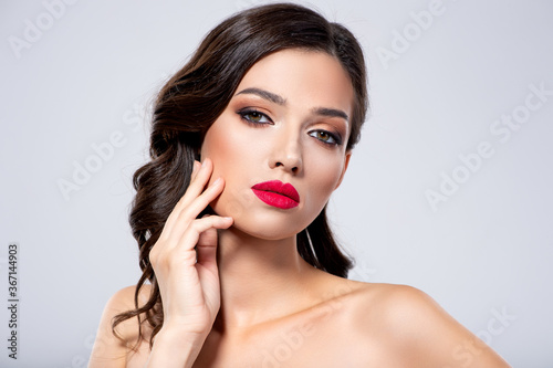 Beautiful young fashion woman with red lipstick. Brunette woman with a clean skin of face. Portrait of model with bright red lips. Glamour fashion model with bright gloss make-up posing at studio.