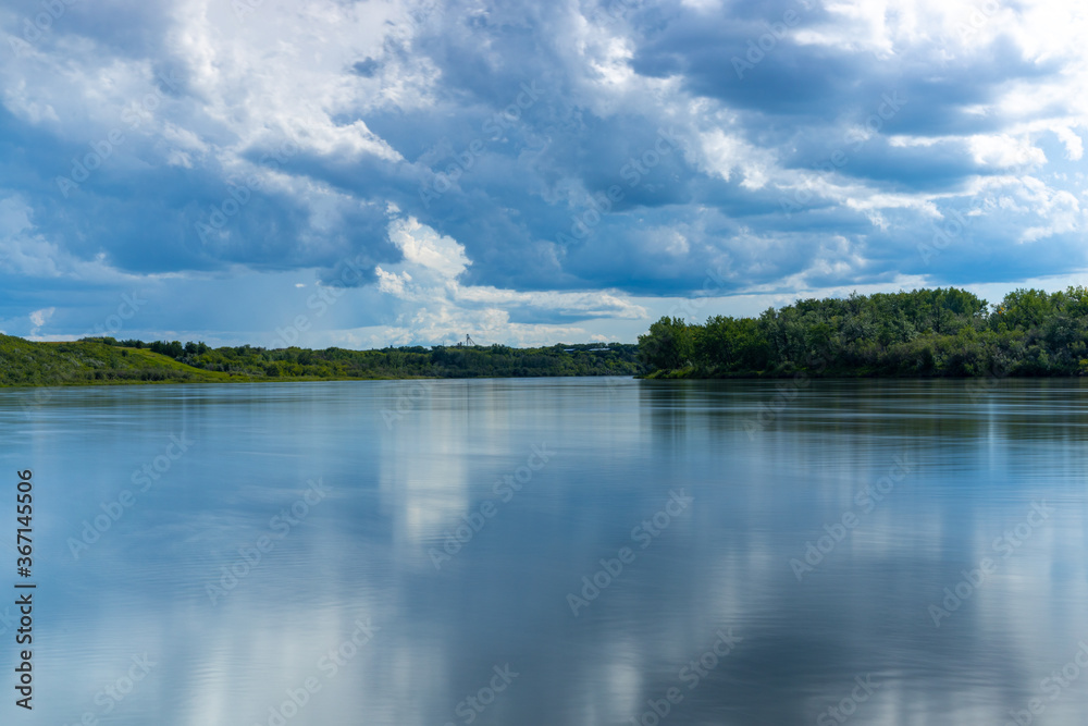 a beautiful view of the South Saskatchewan river in Saskatoon, Saskatchewan Canada. The photo was taken using a long exposure time to create the effect of the smooth water surface a beautiful view of the South Saskatchewan river in Saskatoon, Saskatchewan Canada. The photo was taken using a long exposure time to create the effect of the smooth water surface