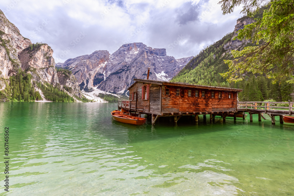 View of the boat house on the famous Lake Braies with emerald water. Italian dolomite alps. (In the background of Seekofel mountain)