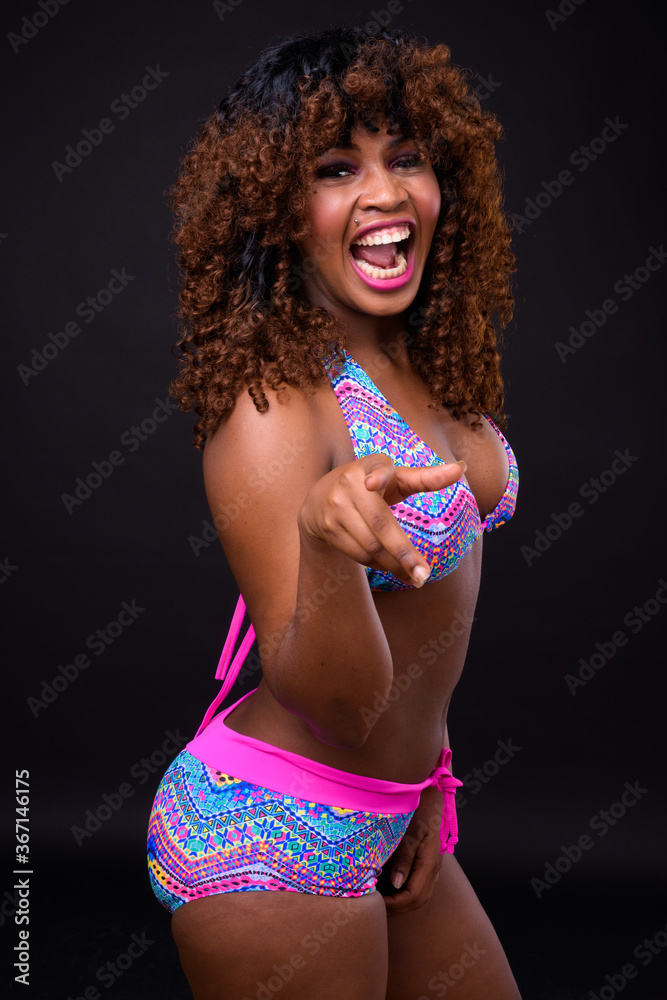 Fototapeta premium Young beautiful African woman against black background