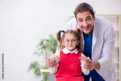 Small girl visiting young male doctor oculist