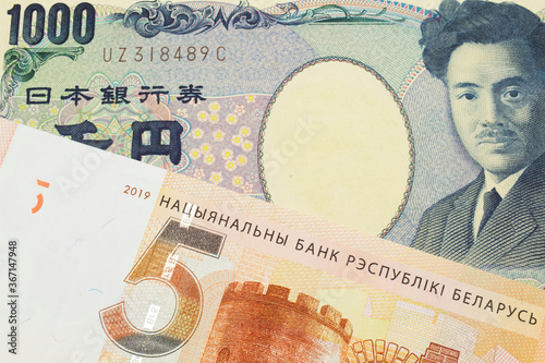 A macro image of a Japanese thousand yen note paired up with a orange five ruble bank note from Belarus. Shot close up in macro.