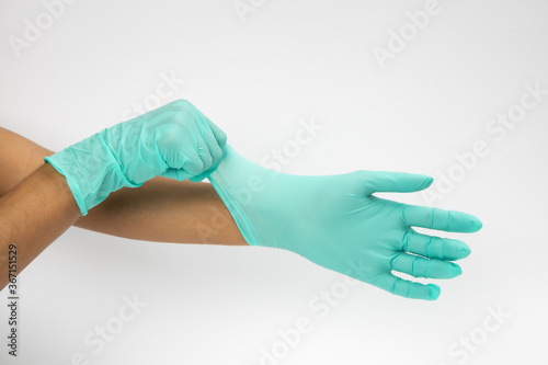 Female hand wears a protective glove for cleaning or tidying. Woman's hand latex glove gesture isolated on white. Female hand putting on latex glove isolated on white background