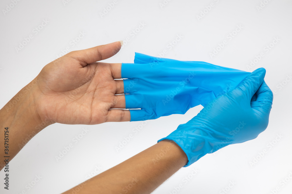 Female hand wears a protective glove for cleaning or tidying. Woman's hand latex glove gesture isolated on white. Female hand putting on latex glove isolated on white background