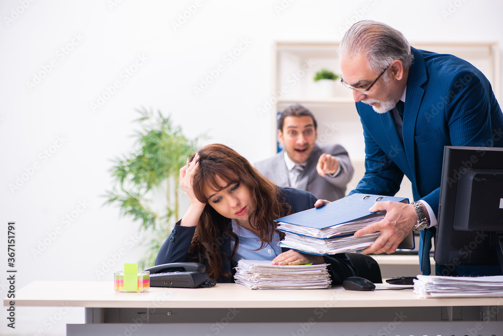 Fototapeta premium Two male and one female employees working in the office