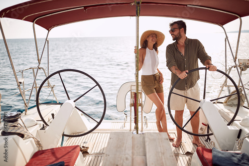 Young handsome couple enjoying a ride on a yacht