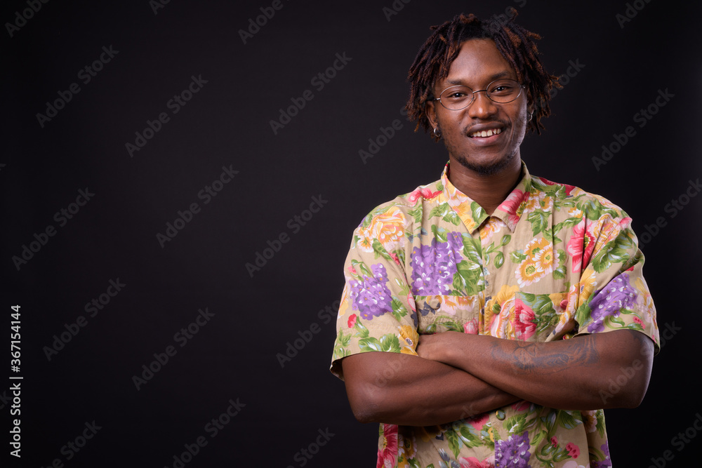 Young African man with dreadlocks against black background Young African man with dreadlocks against black background