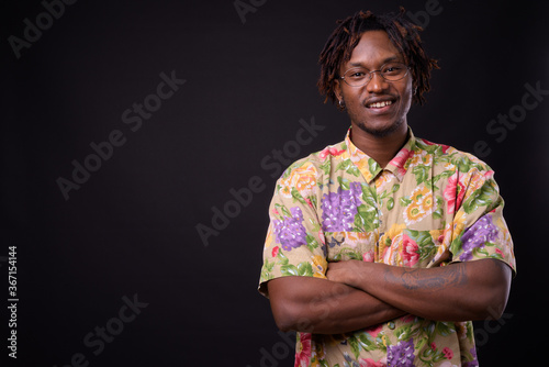 Young African man with dreadlocks against black background