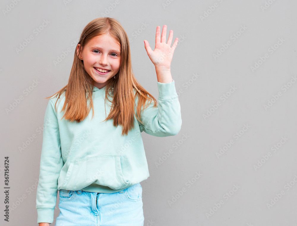 Young beautiful woman with blonde hair congratulating her friend on her birthday. Pretty student girl saying hello, smiling joyfully and friendly, waving her hand Young beautiful woman with blonde hair congratulating her friend on her birthday. Pretty student girl saying hello, smiling joyfully and friendly, waving her hand