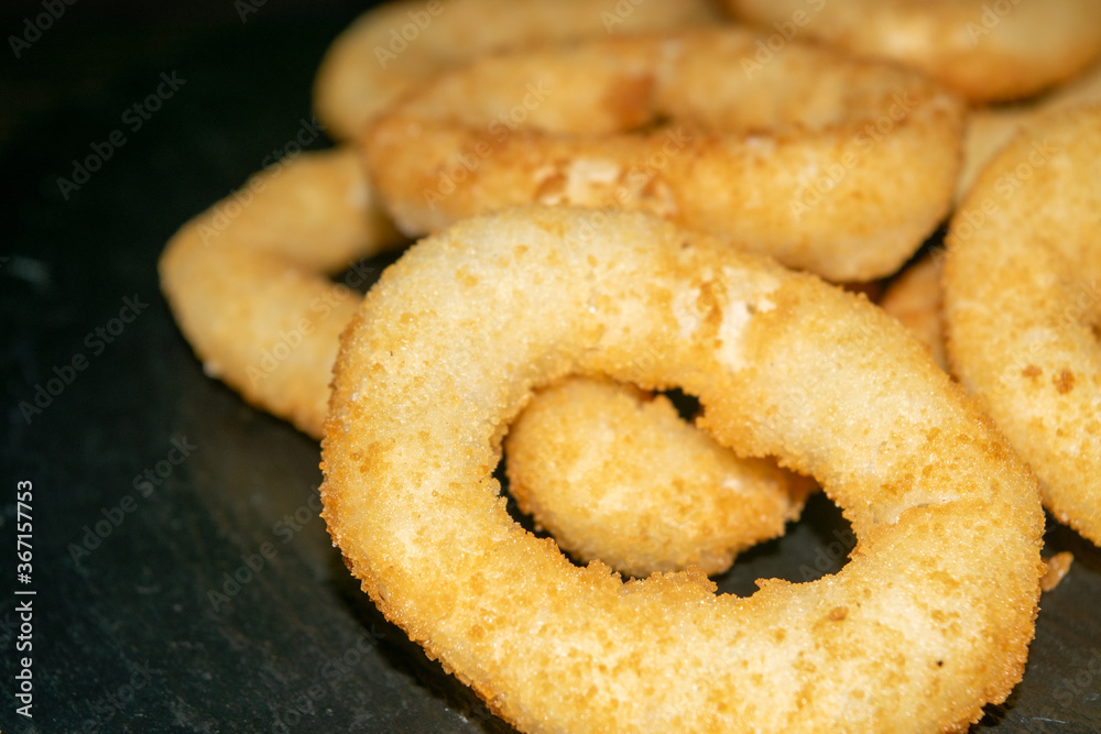 Homemade onion rings on a black table. Close up.