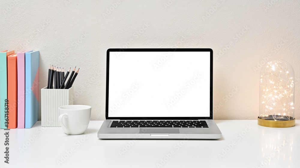 Fototapeta premium Stylish workspace with laptop, lightbulb, coffee cup, office equipment and blank screen laptop on white table in home office. Front view. concept work from home.