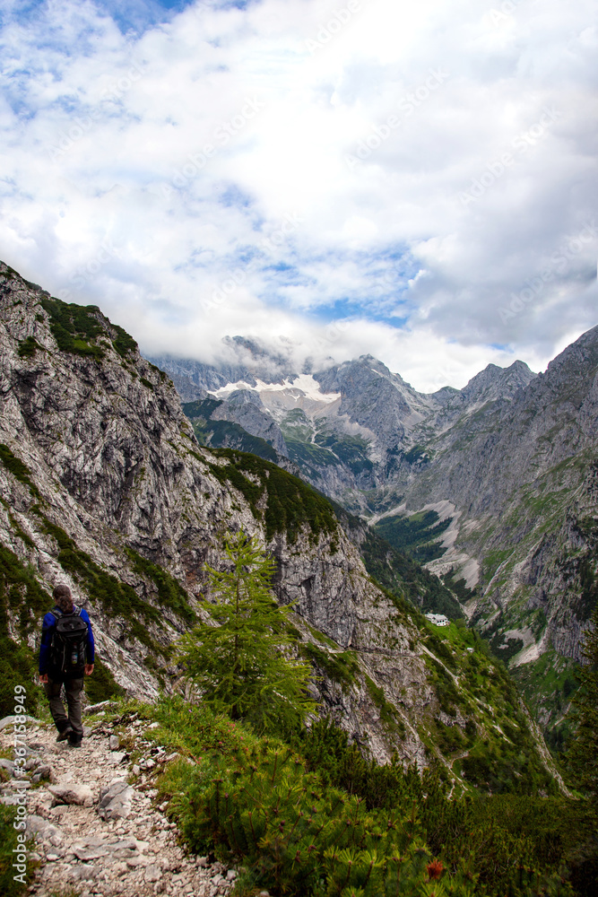male backpacker is hiking. Waxenstein mountain peaks, Flanks of the Zugspitze, Wetterstein Mountains. circular hike over the hupfleitenjoch Kreuzjoch, Wettersteingebirge Bavaria Germany