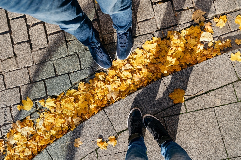 Couple man and woman feet with autumn leaves Couple man and woman feet with autumn leaves