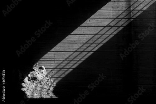 An artistic view of steel railings casting a shadow underneath a bridge. photo