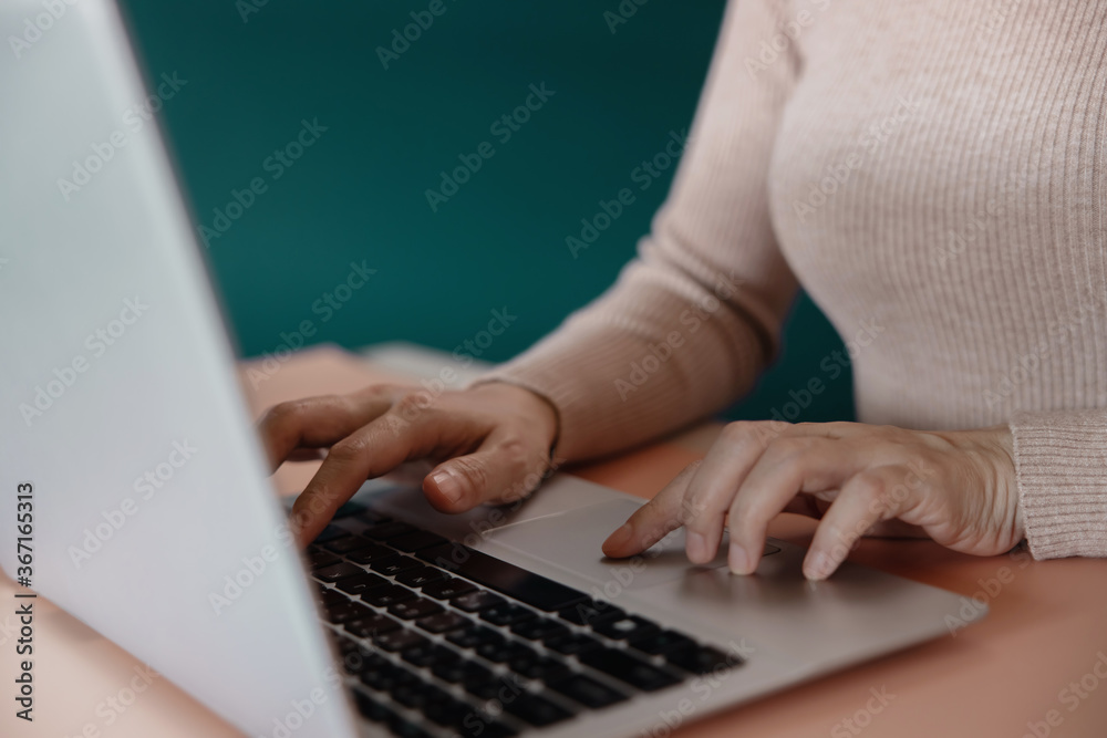 Naklejka premium Young Woman Working on Computer Laptop. Closeup shot and Cropped Image