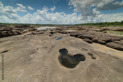 Fotografia Nature landscape photo view of scoured rock field with a hole looks like cartoon character and blue sky with cloudy at Sam Phan Bok (Three thousand holes) a canyon beside Mae-Khong river of Thailand