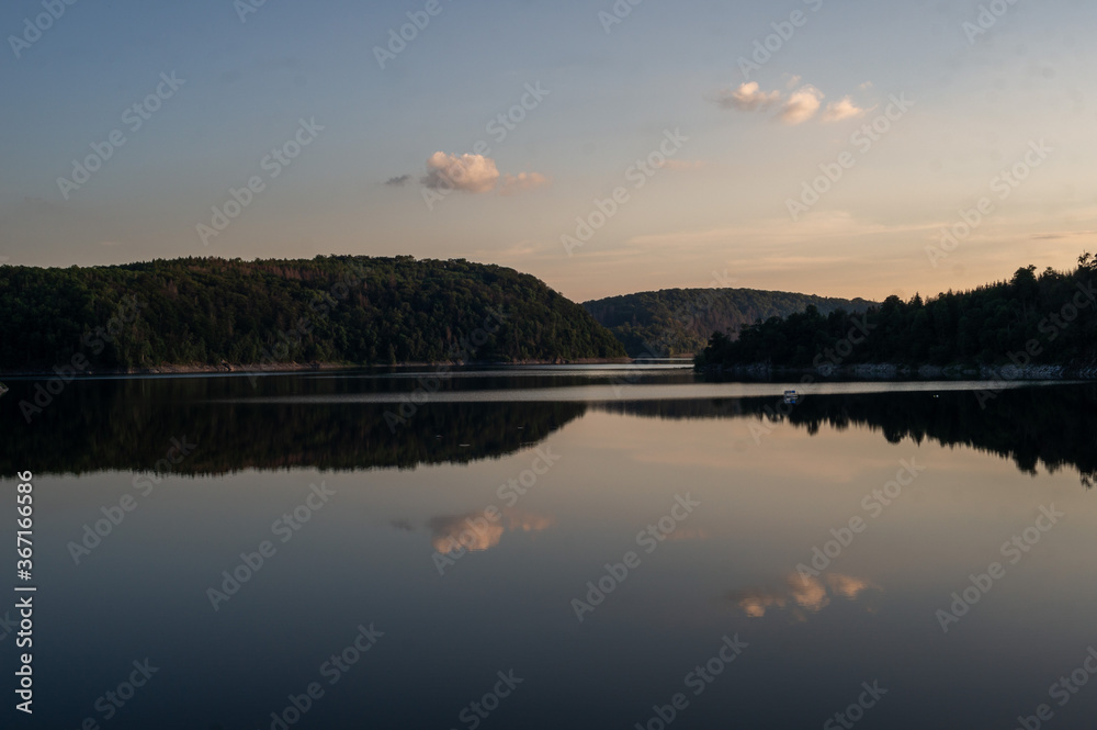 sunset over calm lake. mirroring clouds. Rappbodetalsperre, Harz, Germany