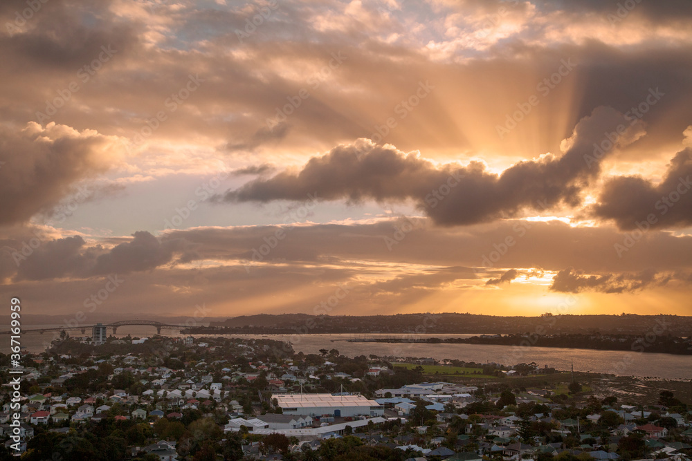 Sunbeams shine through dramatic clouds at sunset in New Zealand. Sunbeams shine through dramatic clouds at sunset in New Zealand.