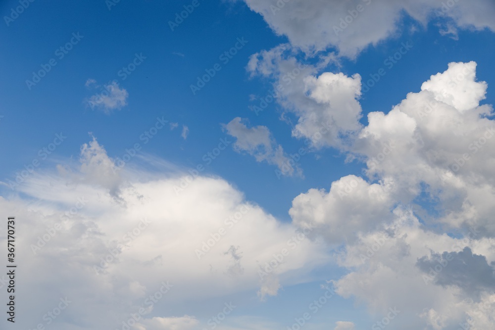 Light blue sky with fluffy white clouds