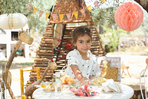 Beautiful girl setting up her birthday table in the country.