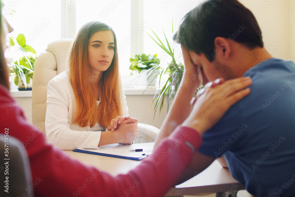 Woman psychologist talking to a young married couple Woman psychologist talking to a young married couple