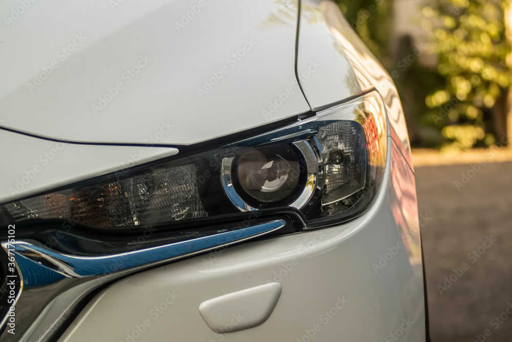 The headlight of a modern car, close-up.