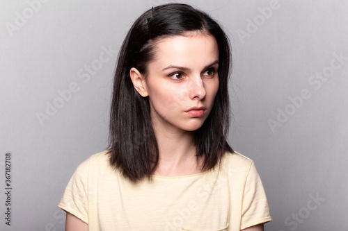 woman in a yellow t-shirt on a gray background