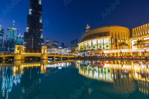 Photography Dubai mall modern architecture and luxury shops reflected in the fountain at blue hour