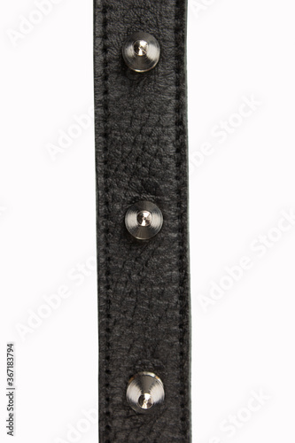 Selective focus black belt with spikes on a white background, close up with no shadows. Black belt with metal spikes for erotic games. Dressed around the neck. Isolate. Place for text.