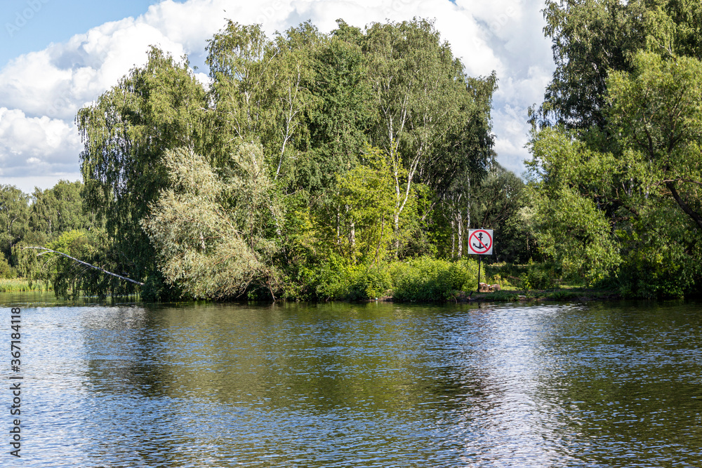 Obraz premium Navigational sign on the bank of the canal prohibiting the stopping of river vessels. Sign for skippers. The anchor is not to throw the mooring of boats is prohibited. Sign on the picturesque Bank.