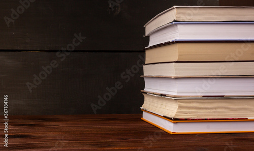 Fotografie Close-up stack of books on a wooden table with space for text