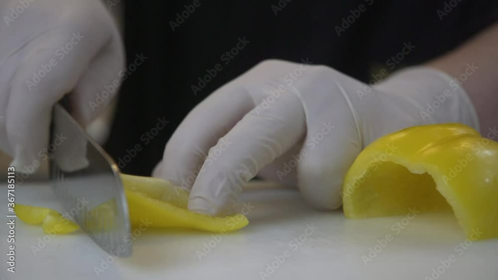 Vídeo cortando un pimentón, manos con guantes con un cuchillo afilado 4k