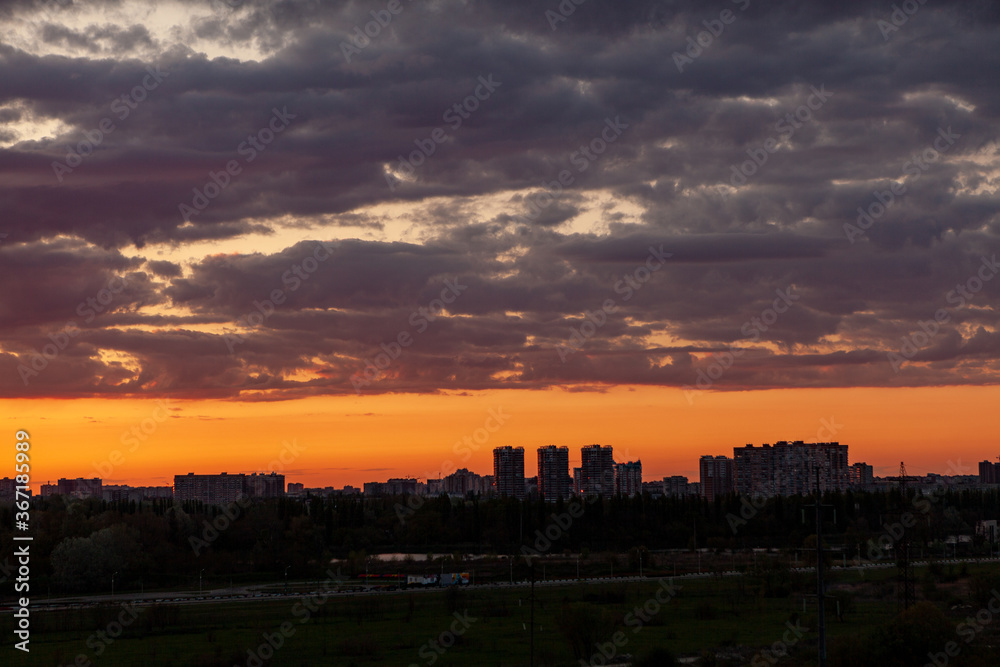 Sunset over the city. Sunset sky with beautiful clouds