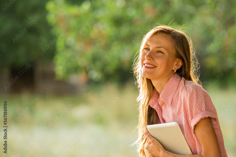 young woman holding a book, table in the park young woman holding a book, table in the park