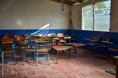Slika na platnu Inside a classroom with chairs and desks in a public school class in Nicaragua
