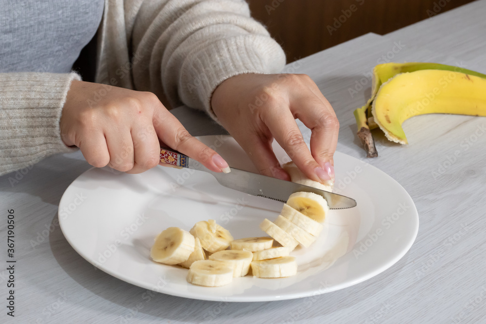 hands chopping a banana with a knife hands chopping a banana with a knife