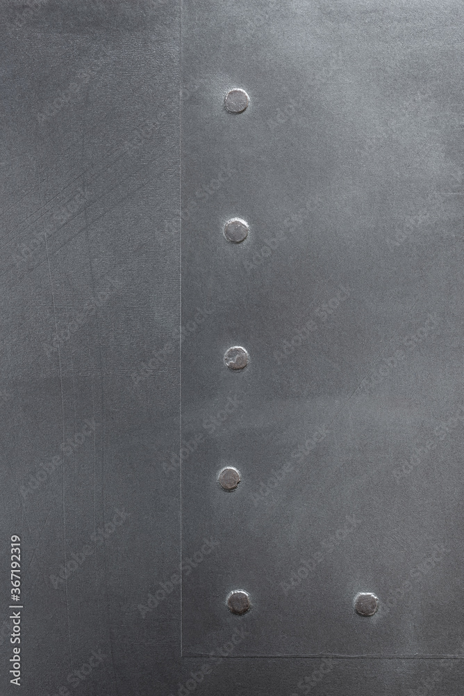 Textured gray vertical background. Decorative plaster imitating a metal surface. Interior wall decoration close-up.