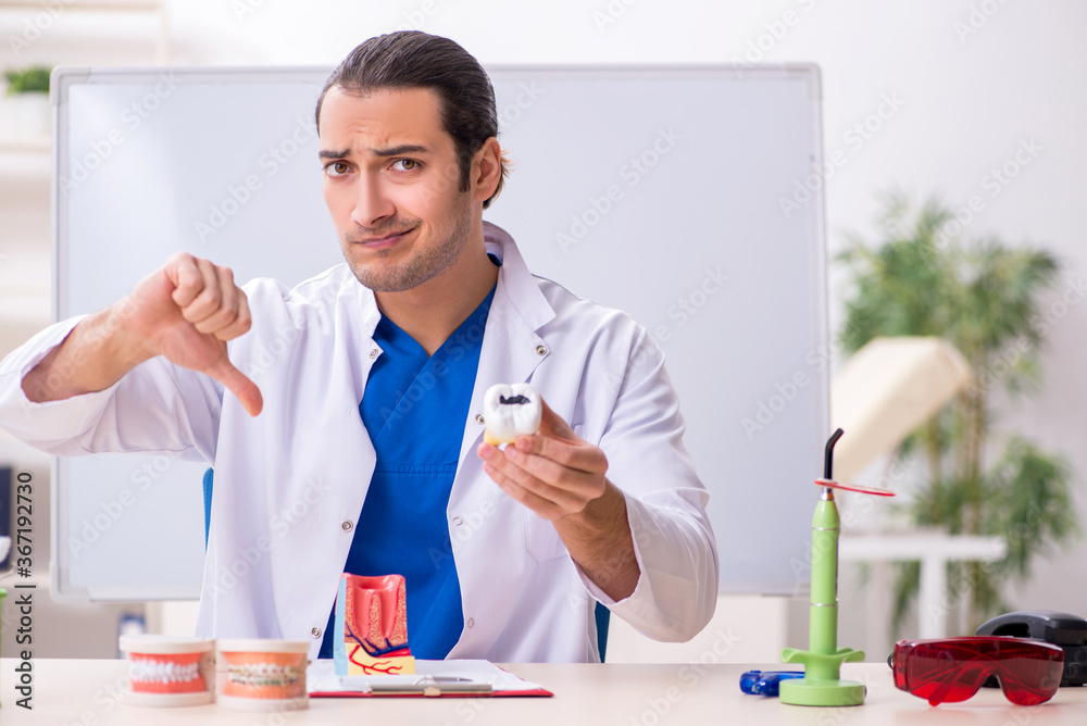 Young male dentist working in the clinic Young male dentist working in the clinic